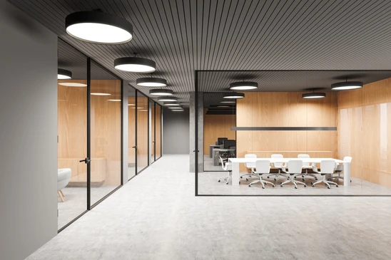 Salle de réunion moderne avec deux chaises design vertes autour d'une table ronde, située dans un espace architectural contemporain